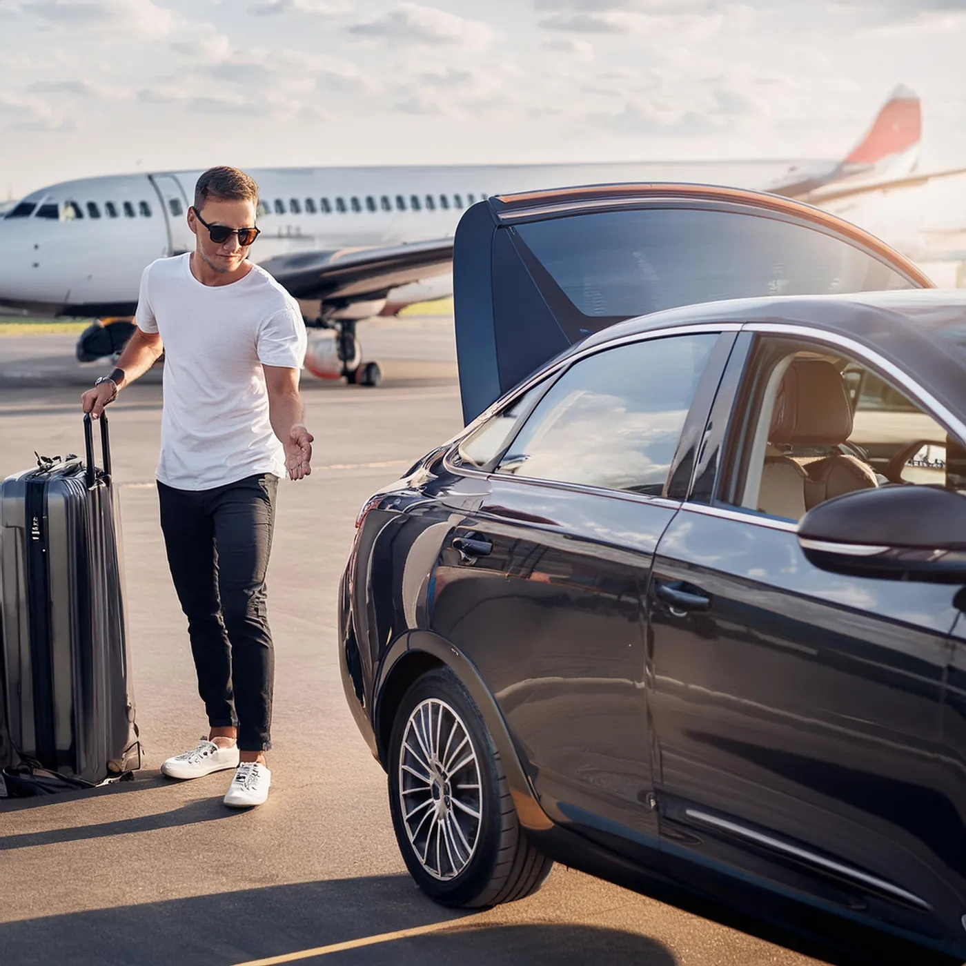 Driver with luggage next to a plane