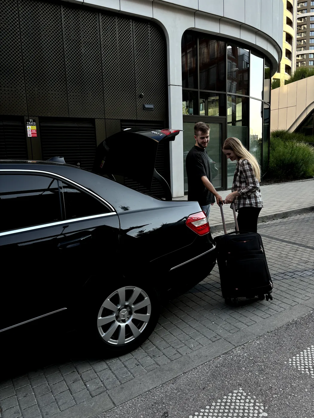 Driver loading a suitcase into the car